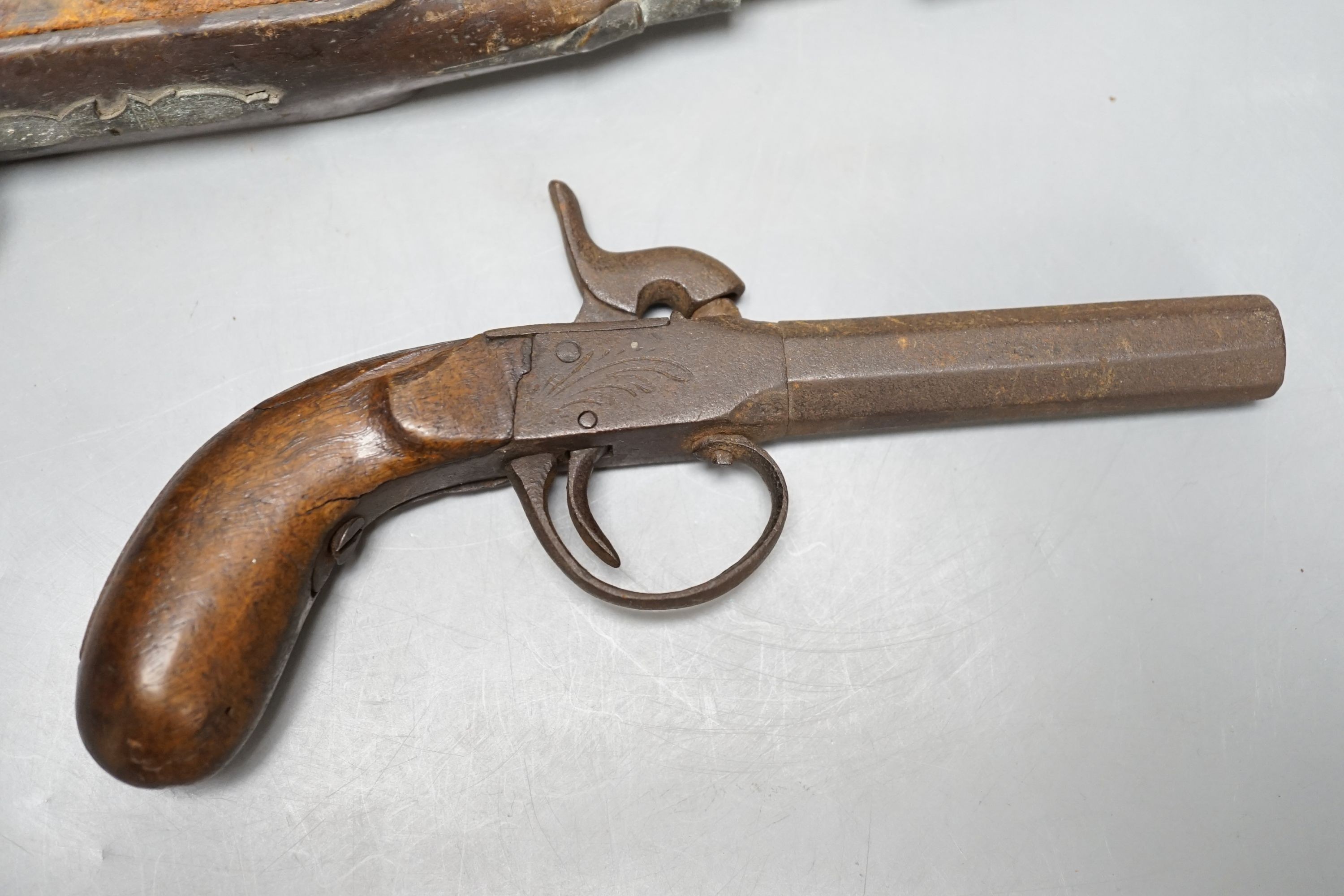 Two 19th century flintlock pistols and a pocket pistol, largest 40 cms long.